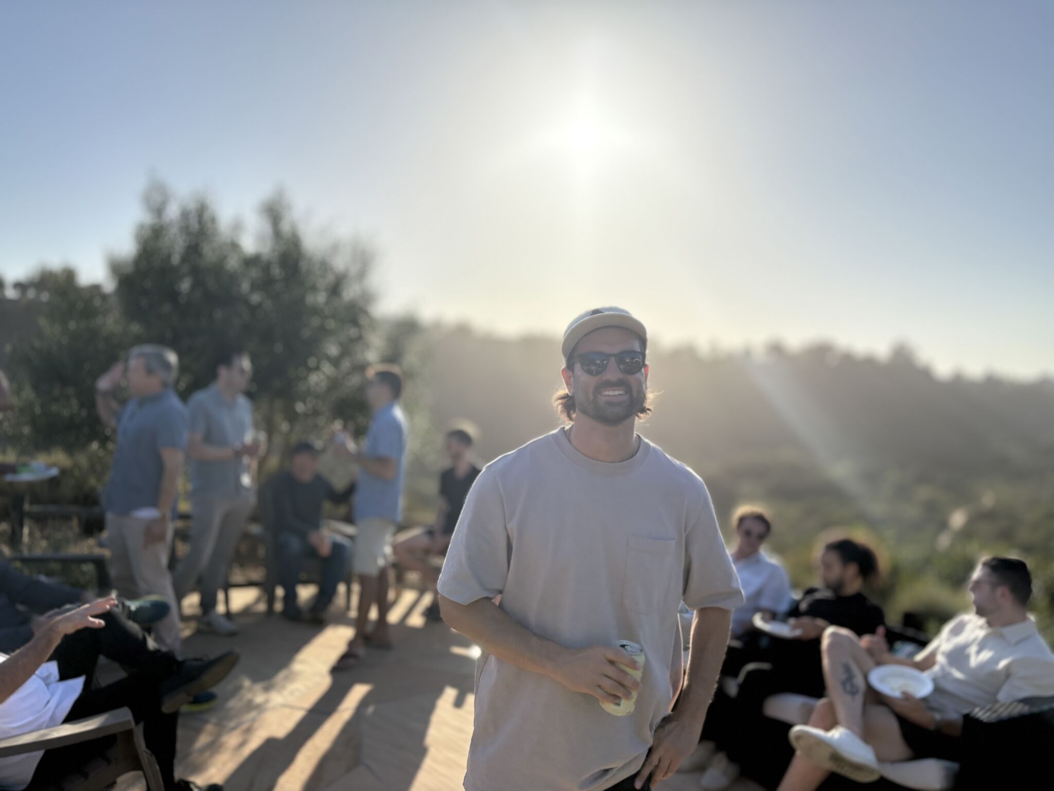 Jonah at a community gathering at golden hour with founders in the background